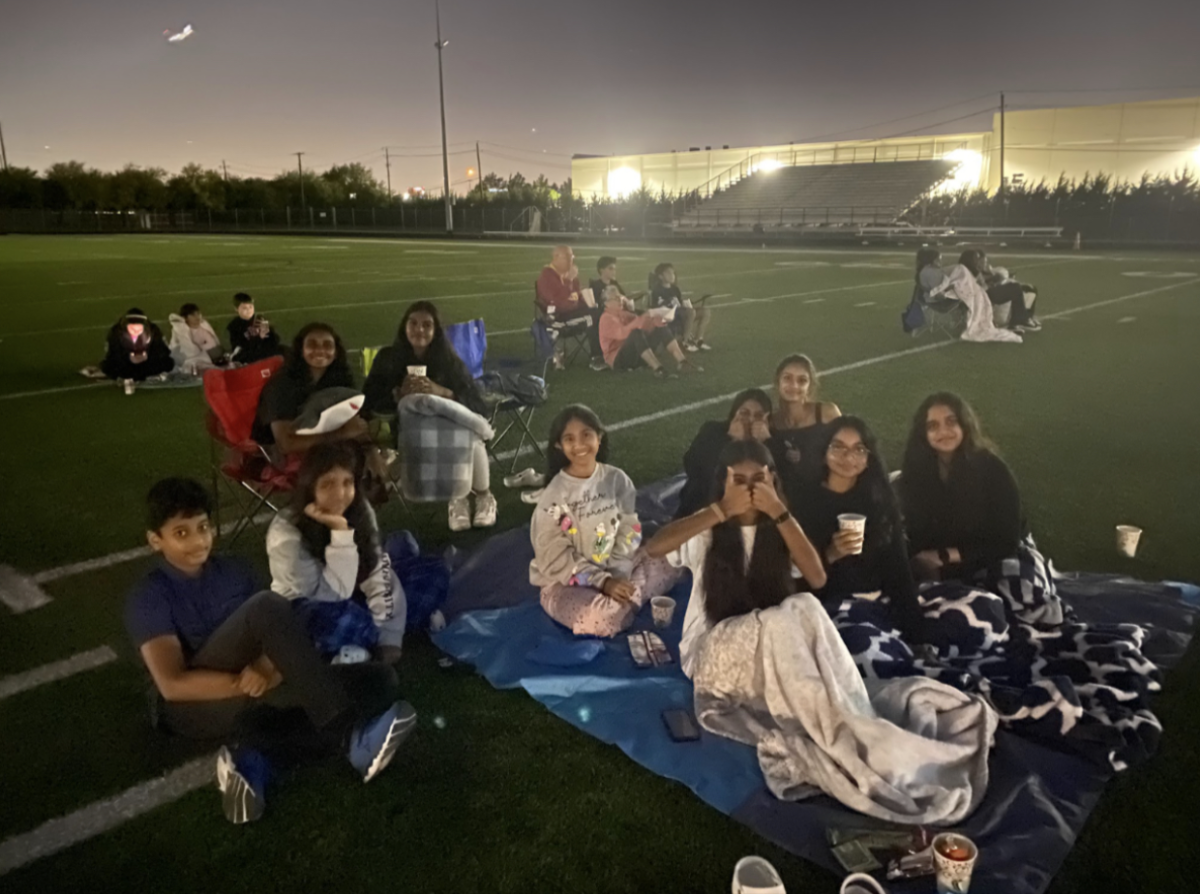 A group of CHS9 students sit on a blanket together to watch Spider-Man: Into the Spider-Verse at the CHS9 family movie night. The movie night was held at Lesley Field on Saturday.